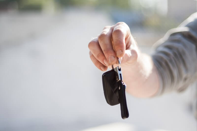 Mann hält einen Autoschlüssel